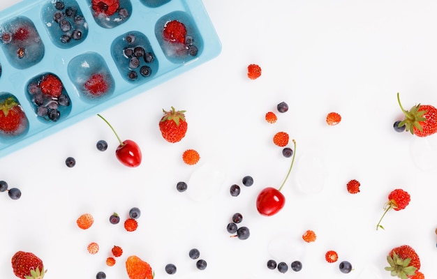 Verse en bevroren zomerbessen aardbeien frambozen bosbessen kersen wilde aardbeien op een witte achtergrond bovenaanzicht banner voor de site