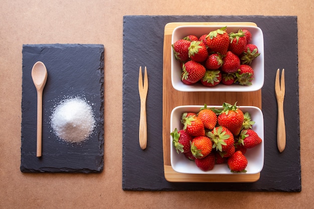 Verse en rijpe aardbeien in witte kommen