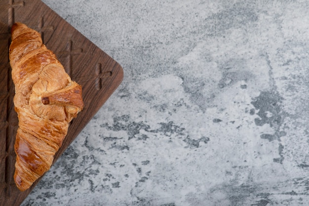 Verse en smakelijke croissants op een houten snijplank.