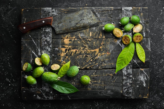 Verse feijoa-vruchten op een houten plank Vruchten zijn rijk aan jodium Bovenaanzicht op een zwarte stenen achtergrond