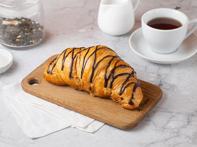 Verse franse chocoladecroissant op houten snijplank croissants met verse rug voor het ontbijt