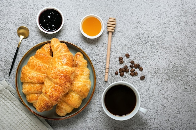 Verse Franse croissants met chocolade op plaat op grijze granietachtergrond