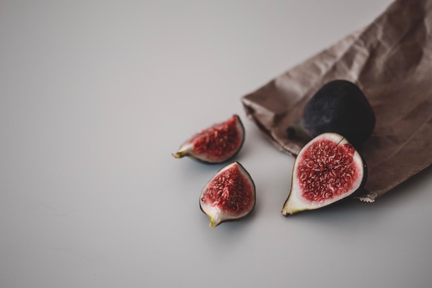 Verse fruitoogst van rijpe vijgen heel en gehalveerd op het bruine kraftpapier Biologisch voedsel Minimalisme kopieerruimte