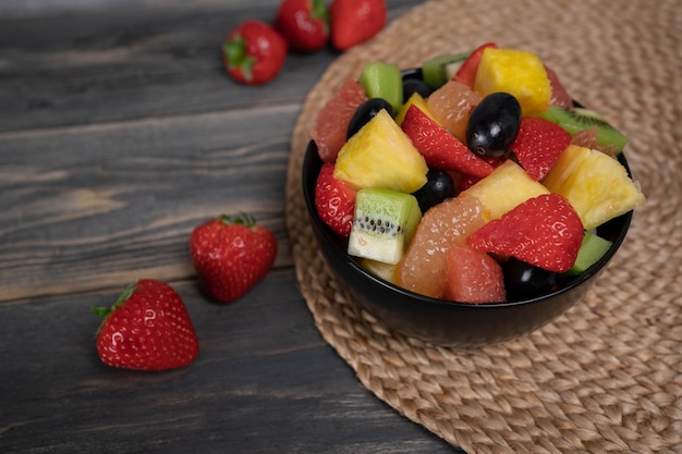 Verse fruitsalade bovenaanzicht in een kom op houten achtergrond vegetarisch voedsel concept BIO fruit