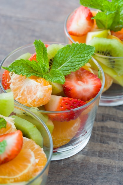 Verse fruitsalade in glas op houten tafel