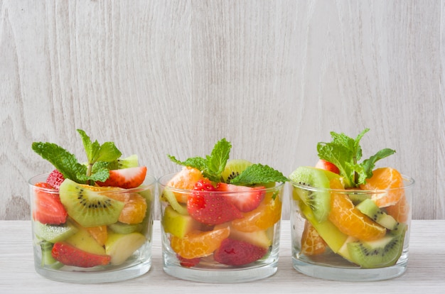 Verse fruitsalade in glas op houten tafel