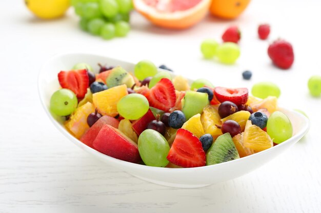 Verse fruitsalade op witte houten tafel