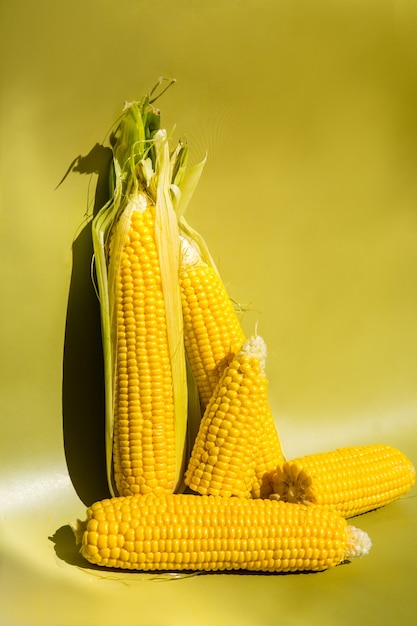 Verse gele maïskolven op groene achtergrond verse groenten