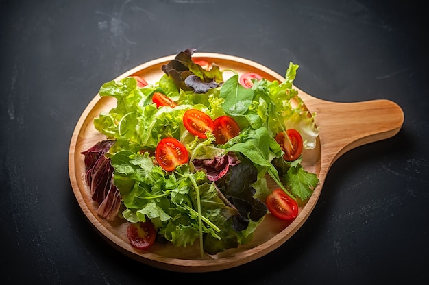 Verse gemengde groentesalade op een houten plaat