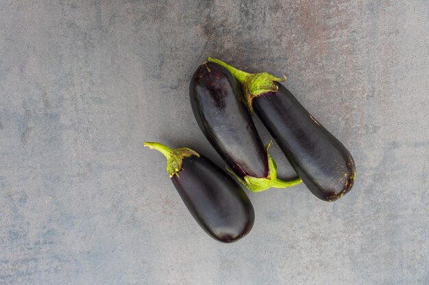 Verse gezonde aubergines op donkere houten achtergrond.