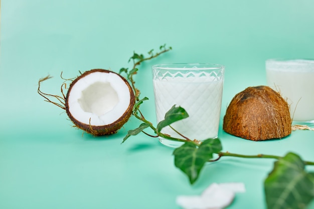 Verse gezonde kokosmelk in een glas op groen oppervlak