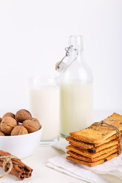 Verse gezonde melkkoekjes met rozijnen, walnoten, kaneelstokjes op witte achtergrond selectieve focus