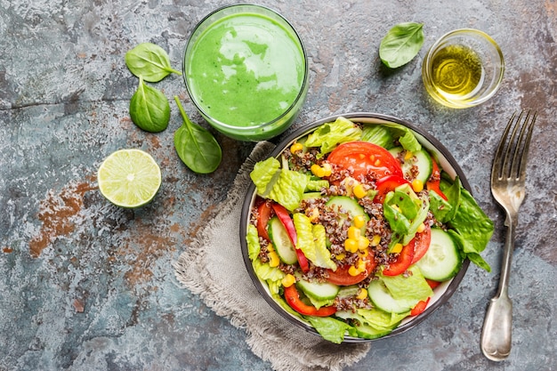 Verse gezonde salade met quinoa, rode tomaten, paprika, komkommer, maïs en avocado op stenen ondergrond, bovenaanzicht. Gezond eten. Superfood maaltijd.