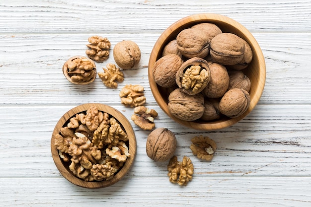 Verse gezonde walnoten in kom op gekleurde tafel achtergrond Bovenaanzicht Gezond eten bertholletia concept Superfoods