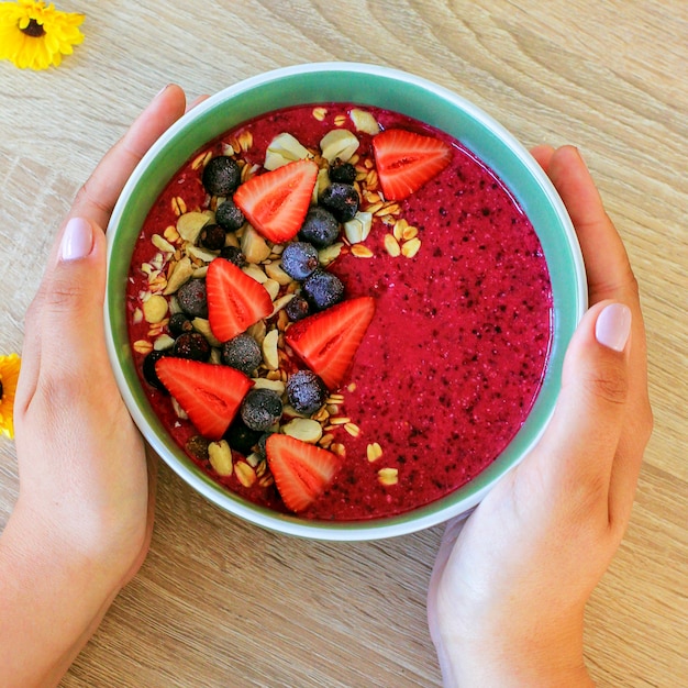 Verse, gezonde zomer bessen smoothie kom met aardbeien, bessen en granola en amandel