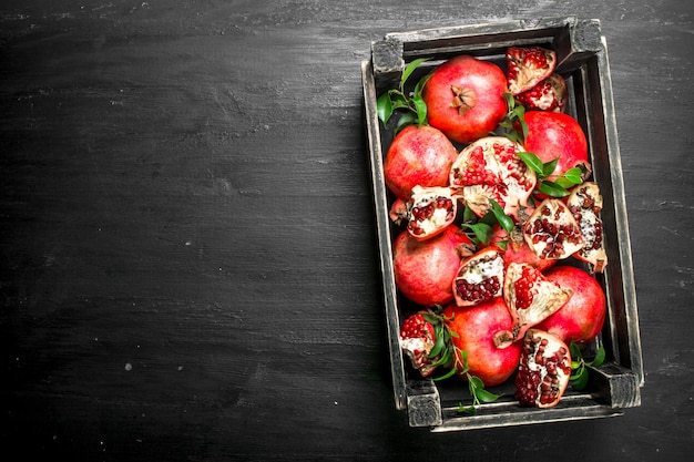 Verse granaatappels in een doos op het zwarte bord