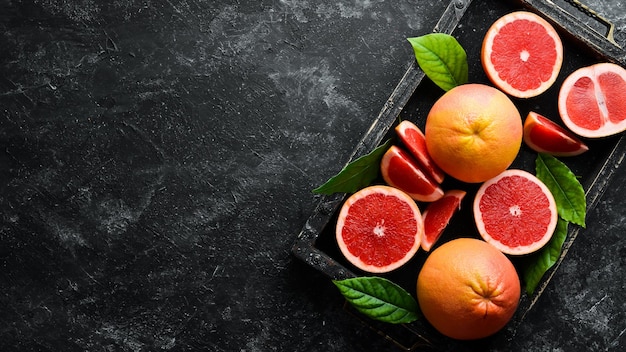 Verse grapefruits in een houten kist Citrusvruchten op stenen achtergrond Bovenaanzicht Gratis kopieerruimte