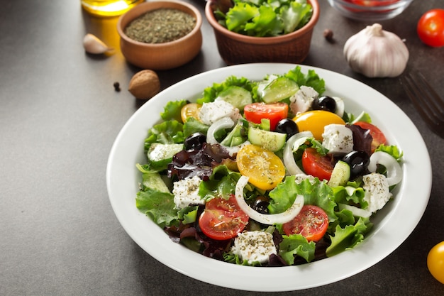 Verse Griekse salade in plaat op stenen tafel