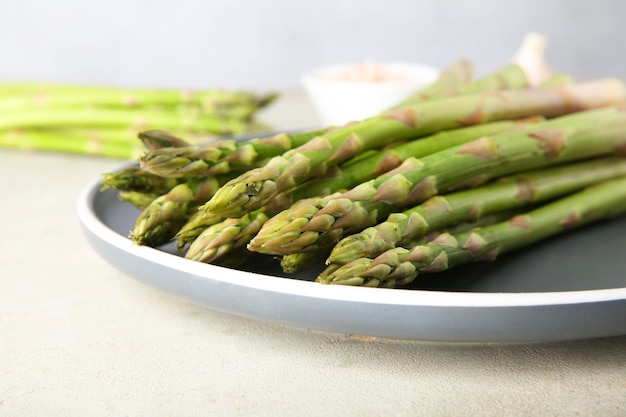 Verse groene asparagusstengels op een grijze tafel close-up