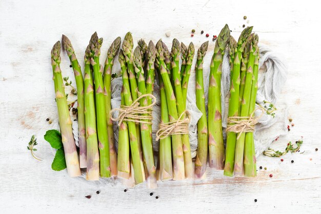 Verse groene asperges op een witte houten achtergrond. Gezond eten. Bovenaanzicht, gratis kopieerruimte.