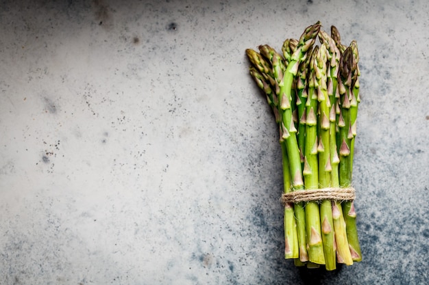 Verse groene asperges op grijs