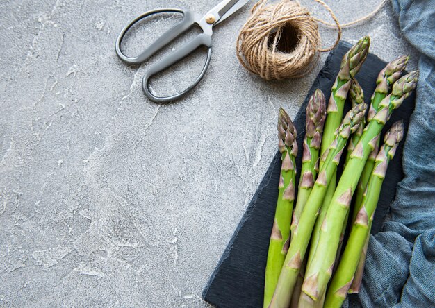 Verse groene asperges op grijze betonnen ondergrond