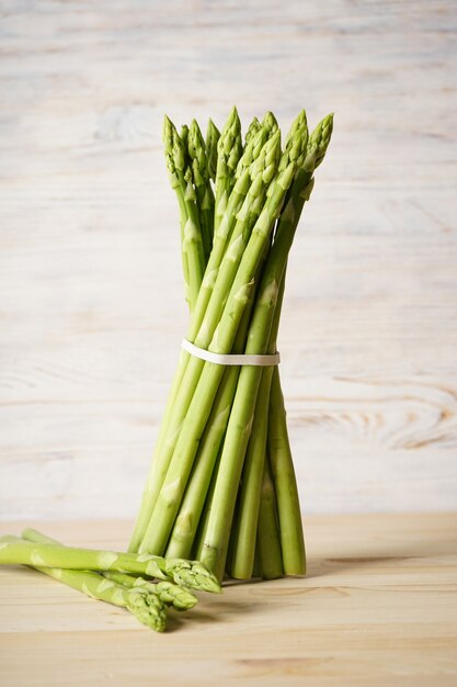 Verse groene asperges op houten oppervlak. Verticaal.