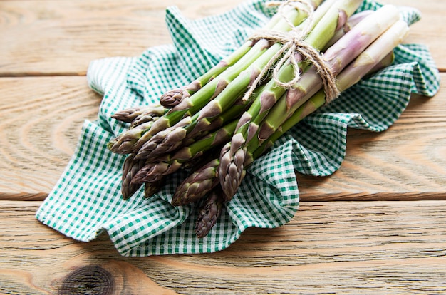 Foto verse groene asperges op oude houten tafel. plat leggen