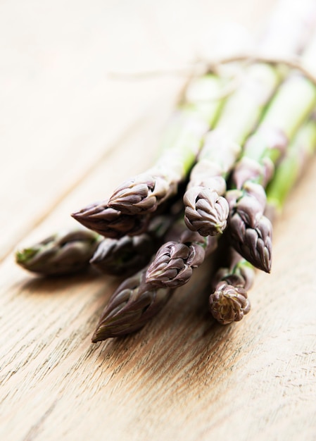 Verse groene asperges op oude houten tafel.