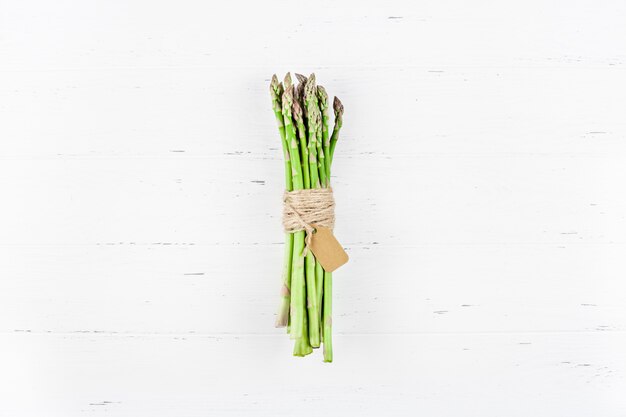 Verse groene asperges op witte houten oppervlak