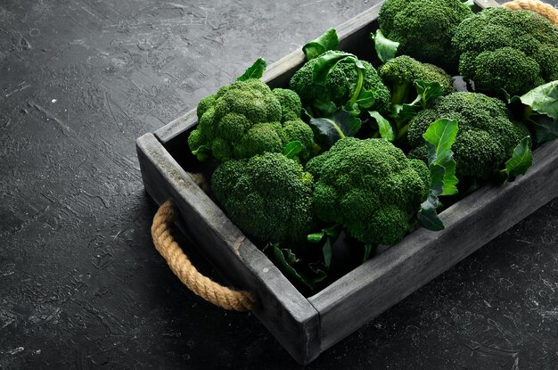 Verse groene broccoli in een houten kist. Bovenaanzicht. Op een zwarte achtergrond.