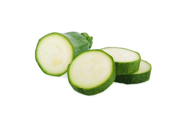 Verse groene courgette met plak die op witte achtergrond wordt geïsoleerd