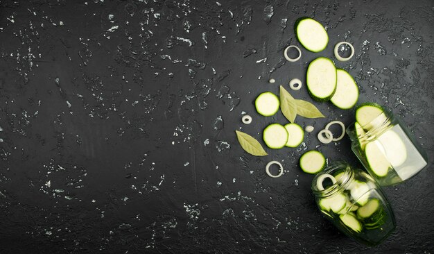 Verse groene courgette op een donkere tafel in bovenaanzicht met kopie ruimte