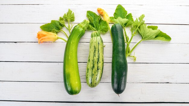 Verse groene courgette op een witte houten tafel Bovenaanzicht Kopieer de ruimte