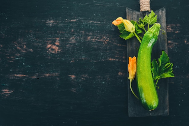 Verse groene courgette op een zwarte houten tafel Bovenaanzicht Kopieer de ruimte