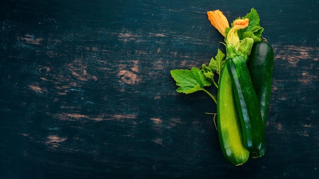 Verse groene courgette op een zwarte houten tafel Bovenaanzicht Kopieer de ruimte