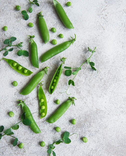 Foto verse groene erwten en groene erwtjes met spruiten op betonnen achtergrond