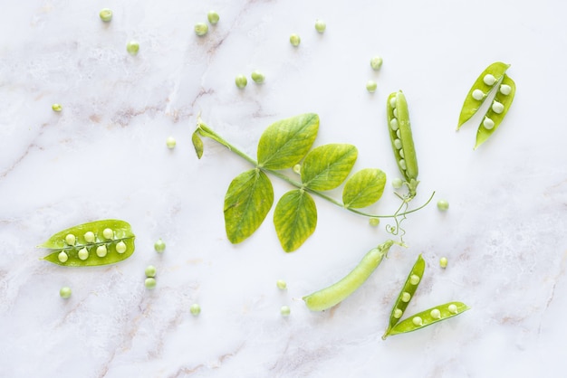 Verse groene erwten op marmeren tafel. Zomer veganistisch concept.