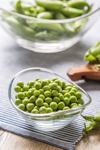 Verse groene erwtenzaden in kom op keukentafel.