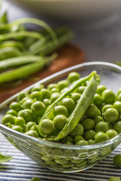 Verse groene erwtenzaden in kom op keukentafel.