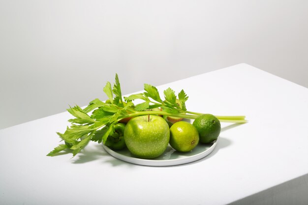 Verse groene groenten en fruit op witte tafel. Alkalisch dieetconcept, horizontale oriëntatie