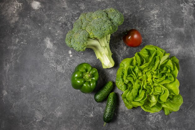 Foto verse groene groenten op een donkere achtergrond, bovenaanzicht met kopie ruimte.