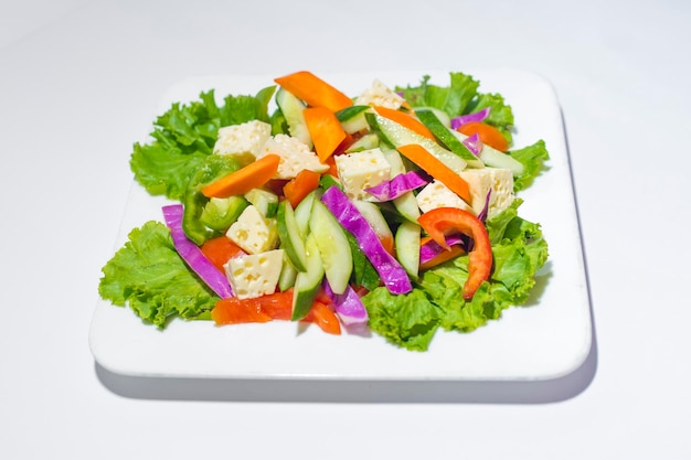 Verse groene groentesalade in een bord Gezonde capsicume wortel kaas tomaat en sla maaltijd op witte achtergrond