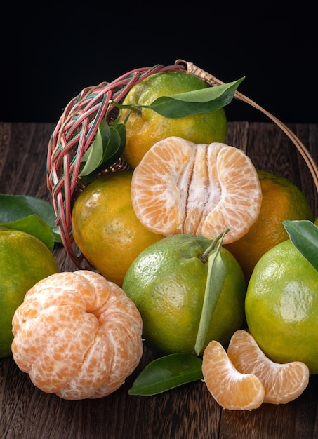 Foto verse groene mandarijn mandarijn sinaasappel op donkere houten tafel achtergrond