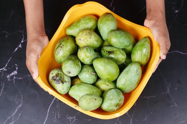 Verse groene mango in een kom op tafel