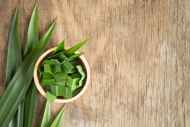 Verse groene pandan op houten lijst, pandanbladeren op oude houten achtergrond