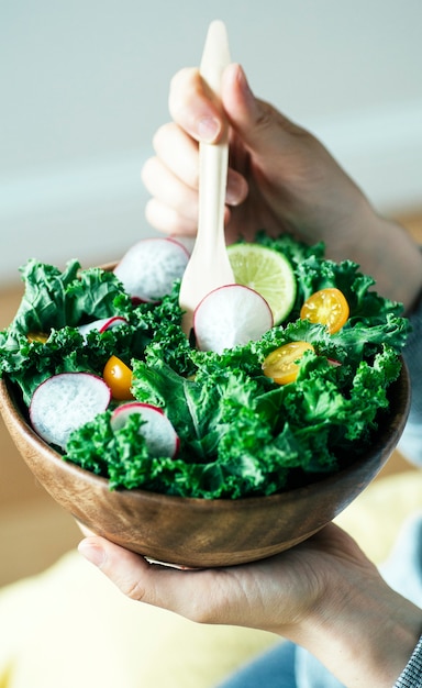 Verse groene salade in een houten kom.