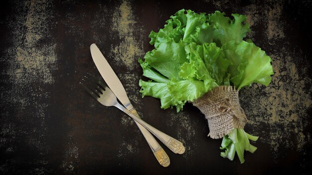 Verse groene slablaadjes op een donkere tafel