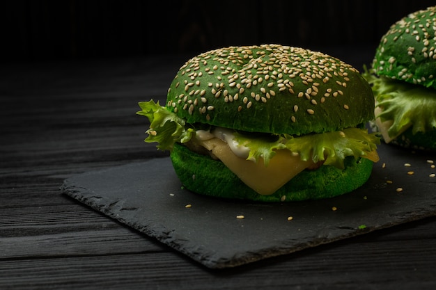 Verse groene smakelijke hamburger op zwarte achtergrond