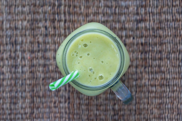 Verse groene smoothie van avocado-kiwi-banaan en honing in glazen mok op houten achtergrond close-up Concept van gezond eten